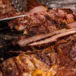 Close-up of sliced grilled beef with rich seasoning at a traditional Brazilian barbecue in Londrina.